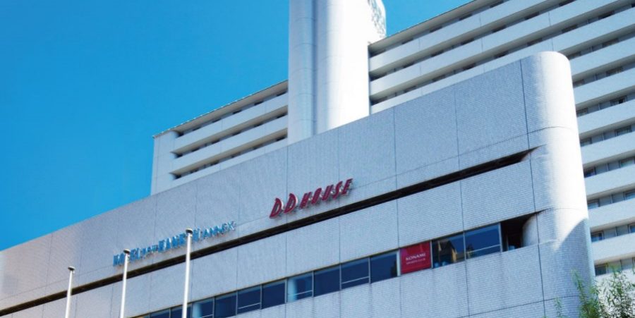 A large white building featuring a prominent red sign on its facade.